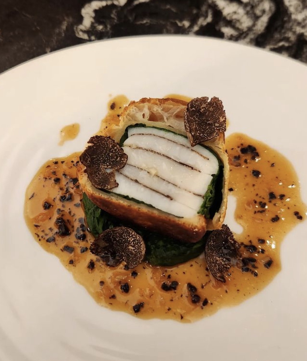 A fine-dining fish course with truffle and sauce